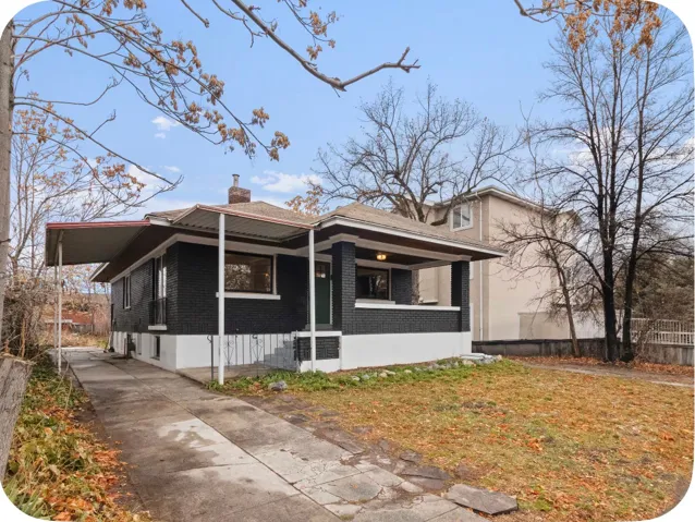 Exterior featuring a covered porch, attached carport, and a paved driveway