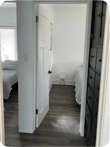 Wood-finish flooring throughout, bright white walls, and paneled interior doors