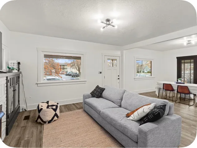 Wood-finish flooring throughout, white trim molding, recessed lighting, and a paneled entry door with frosted glass detailing