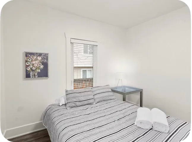 White walls with natural light, wood-finish flooring, and window blinds