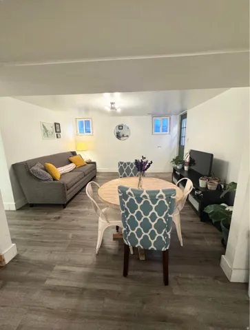 Recessed lighting, wood-finish flooring, two fixed windows, and a panel door