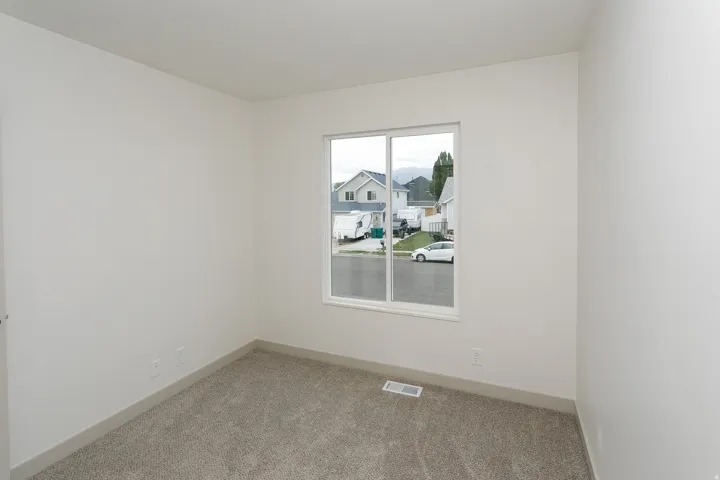 Carpeted room with a double-pane window, white trim, and neutral wall tones