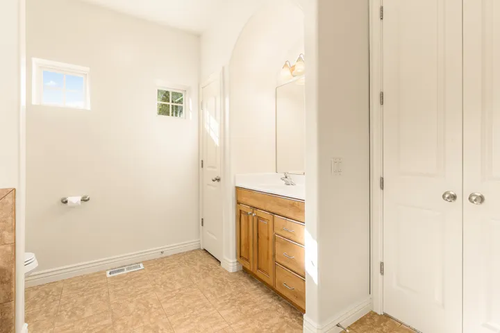 Recessed vanity with a built-in sink, dual windows, and tiled flooring