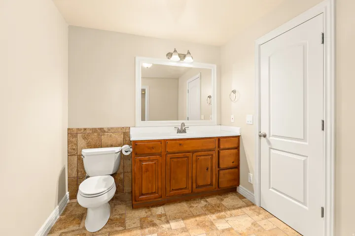 Wood-finish vanity with a white countertop and undermount sink
