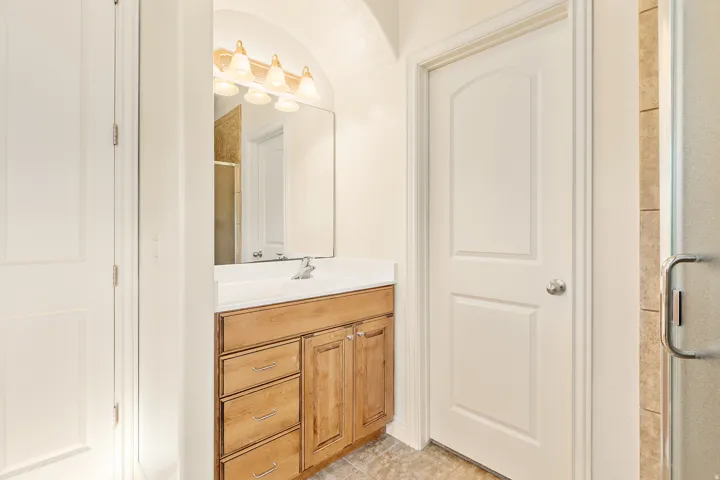 Wood-finish vanity with an integrated sink and chrome faucet