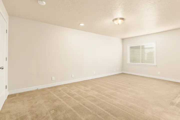 Carpeted room with a flush-mount ceiling light and recessed lighting