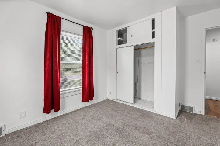 Bedroom with Storage – A generously sized bedroom featuring a built-in sliding-door closet with upper shelving, providing convenient storage right at hand.