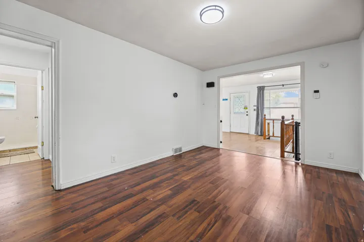 Upper Hallway – A functional hallway connects the bathroom, entry, and staircase, featuring a smart thermostat and built-in security panel for modern convenience.