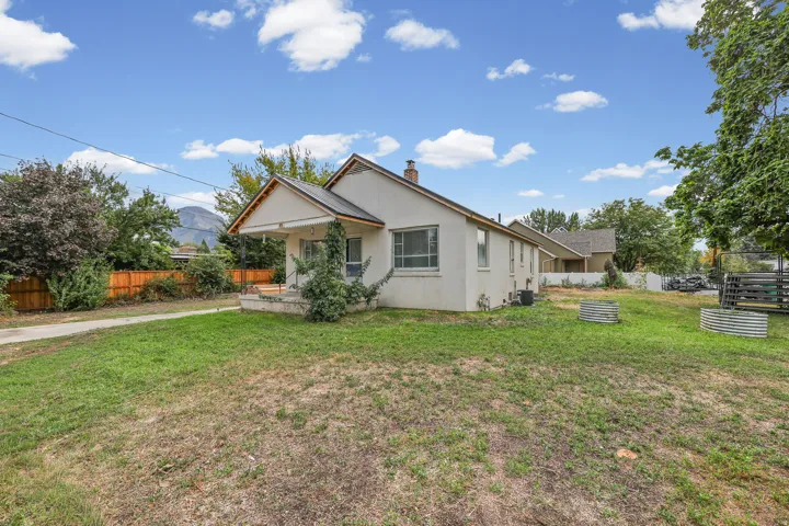 Rear Exterior – The backyard offers a large, open lawn with mountain views and plenty of room for outdoor living or future landscaping projects.