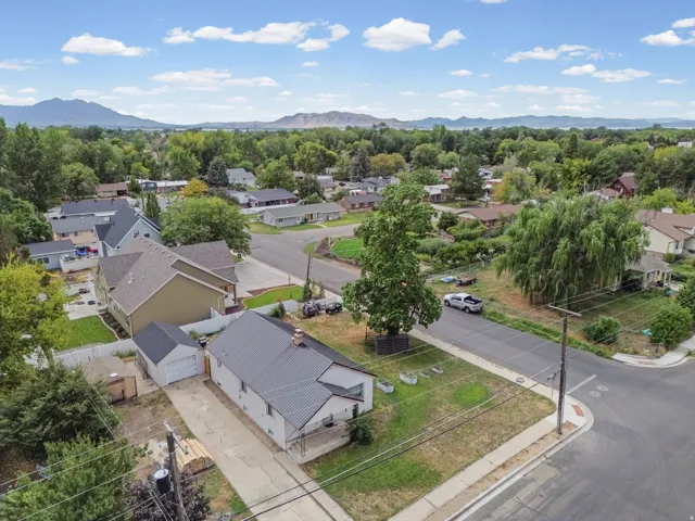 Aerial View – Wide Angle – Set against a dramatic mountain backdrop, this property offers a generous yard with room to garden, entertain, or expand.