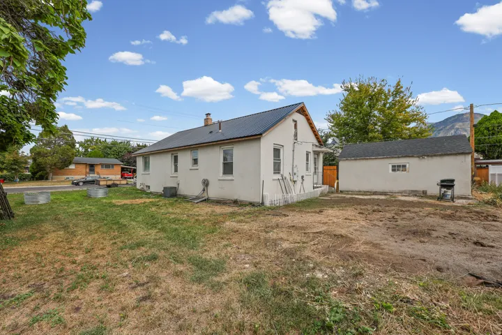 Rear Exterior – The backyard offers a large, open lawn with mountain views and plenty of room for outdoor living or future landscaping projects.