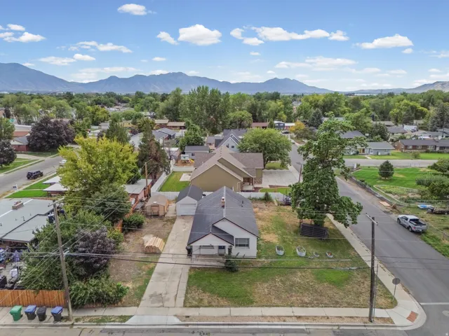 Aerial View – Wide Angle – Set against a dramatic mountain backdrop, this property offers a generous yard with room to garden, entertain, or expand.