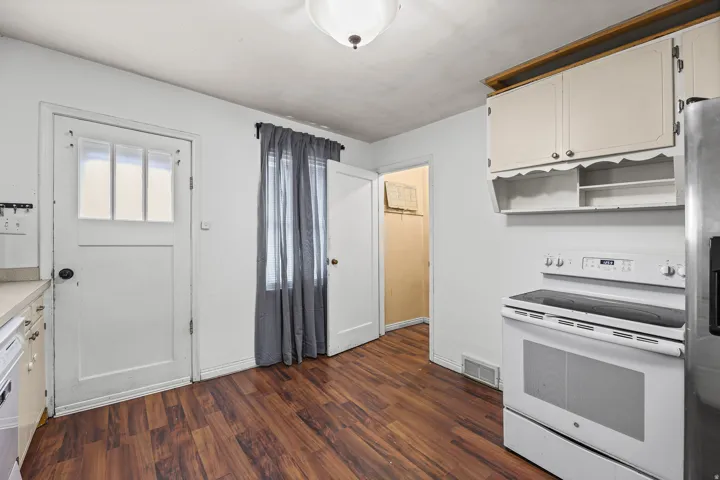Kitchen Nook – A cozy prep area with a side entry door and pantry access, situated alongside the stainless refrigerator and electric range.