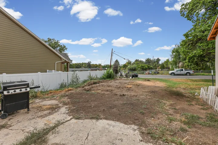 Rear Exterior – The backyard offers a large, open lawn with mountain views and plenty of room for outdoor living or future landscaping projects.