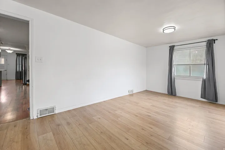 Living Room (alternate view) – This spacious living area flows seamlessly into the adjoining kitchen and hallway, offering an easy, open-concept layout ideal for everyday living.