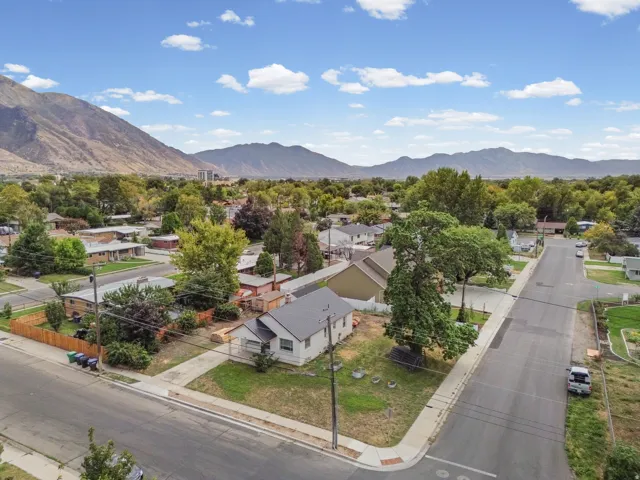 Aerial View – This charming home sits on a spacious corner lot with mature trees and stunning mountain views in the background.