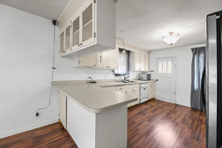 Kitchen – This well-equipped kitchen offers a peninsula counter with bar seating potential, a full appliance suite including a dishwasher, and a sunny window over the sink.