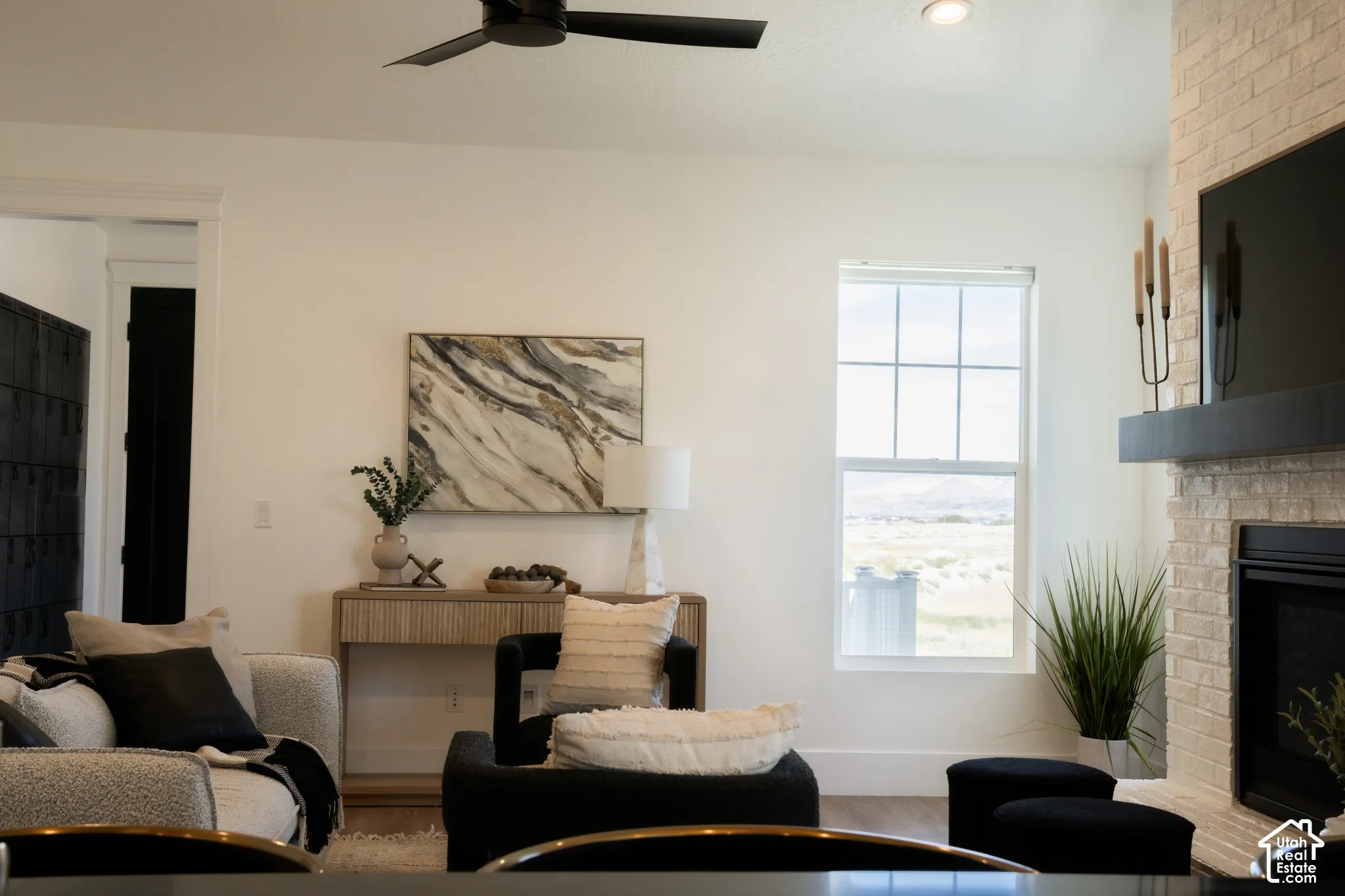 Recessed lighting, ceiling fan, brick-finish fireplace, window with grid pattern, and wood-finish flooring