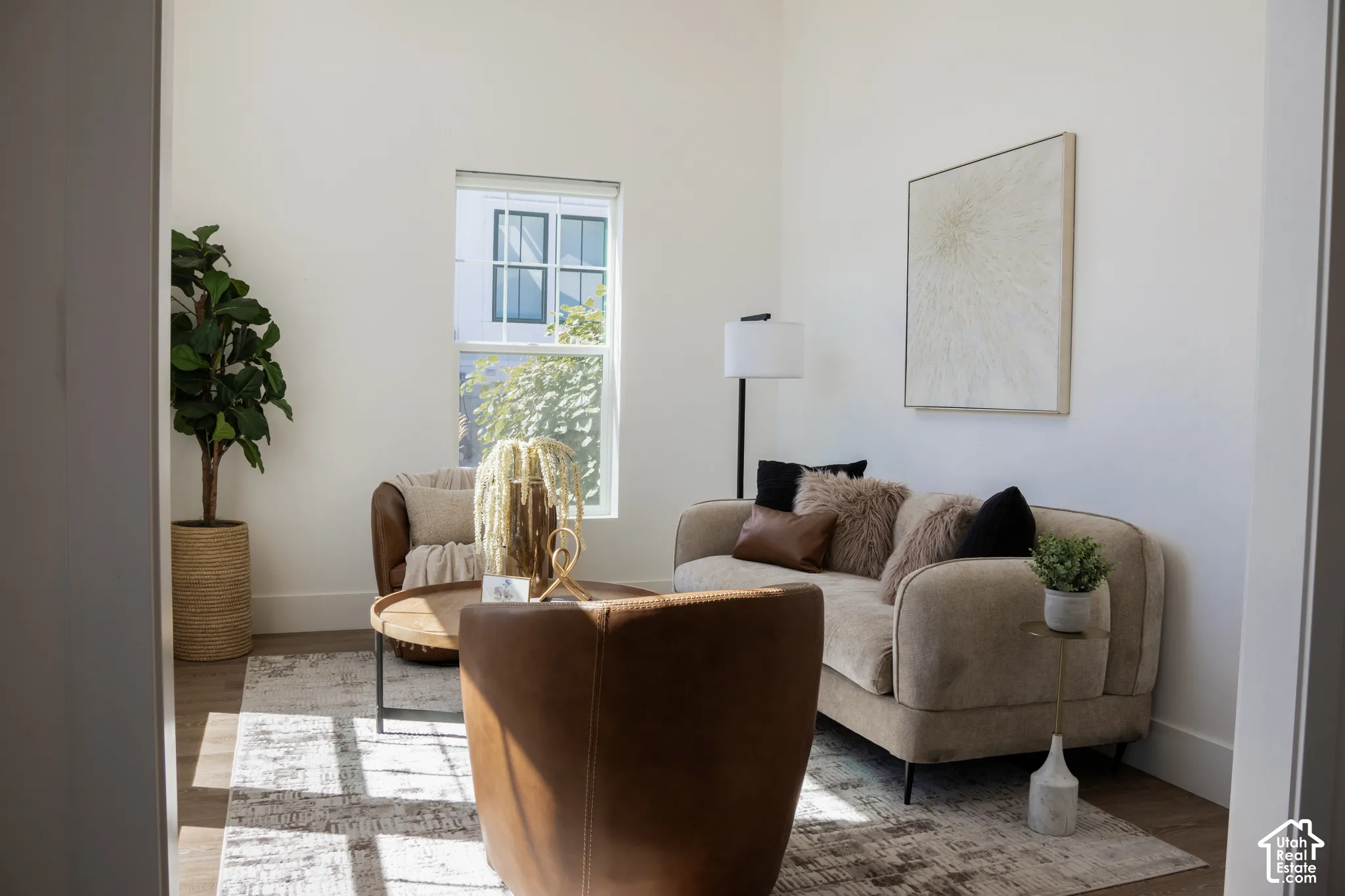 Hardwood-style flooring, white walls, and a large window with white trim