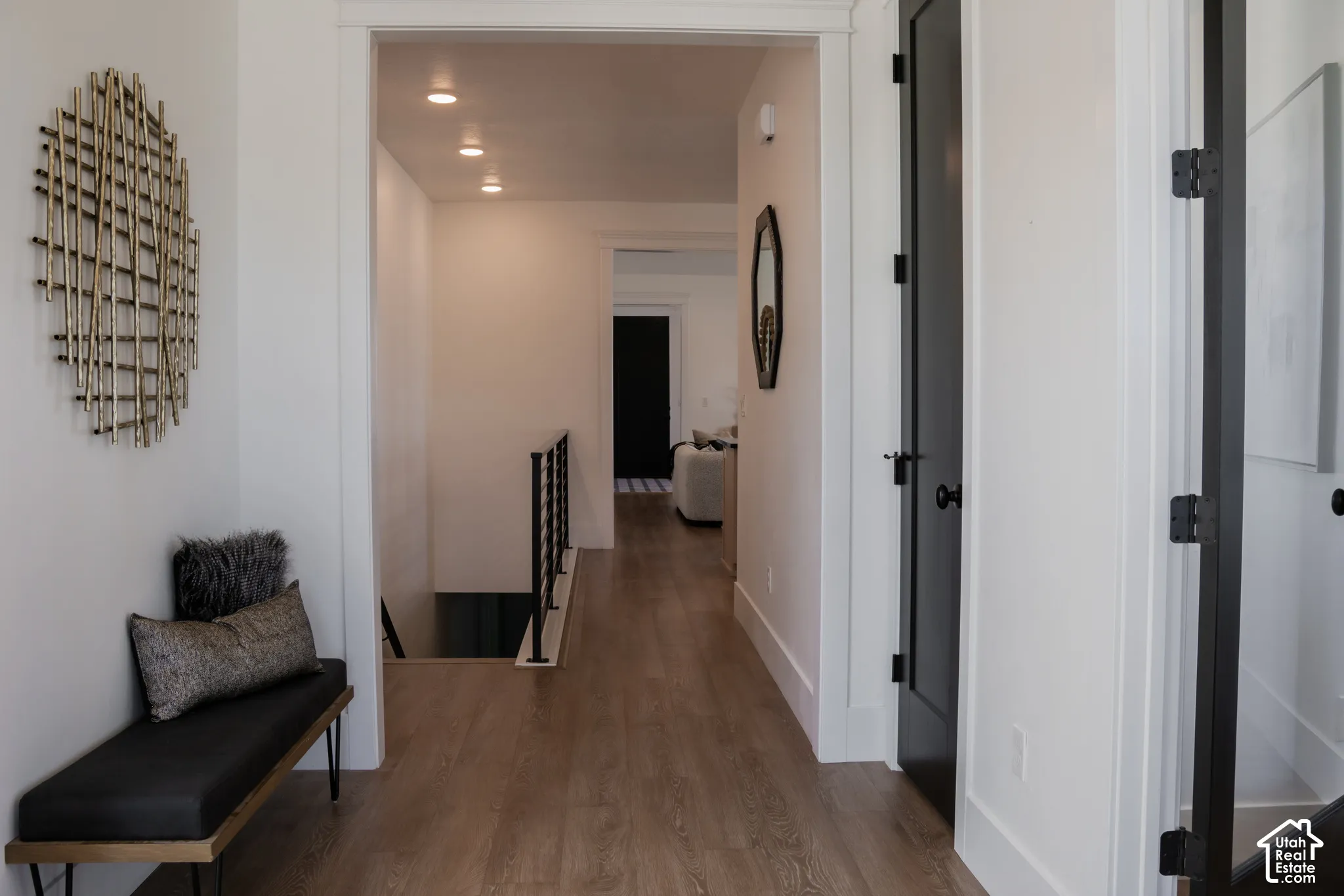 Hardwood-look flooring, recessed ceiling lighting, white trim, and black interior doors