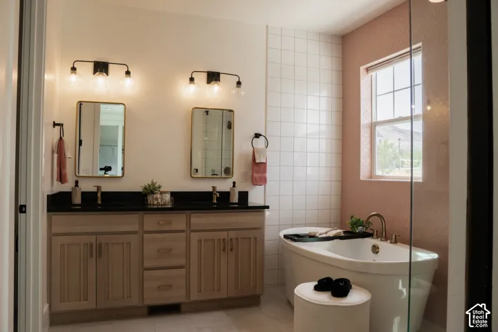 Dual vanity with wood-finish cabinetry, black countertops, and rectangular mirrors