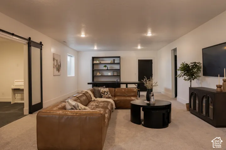 Recessed lighting illuminates this space featuring light-toned carpeting and white walls