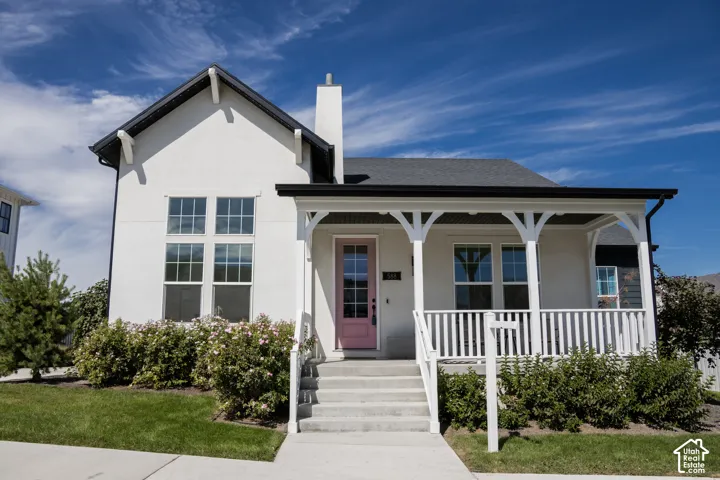White stucco exterior with a dark shingle roof