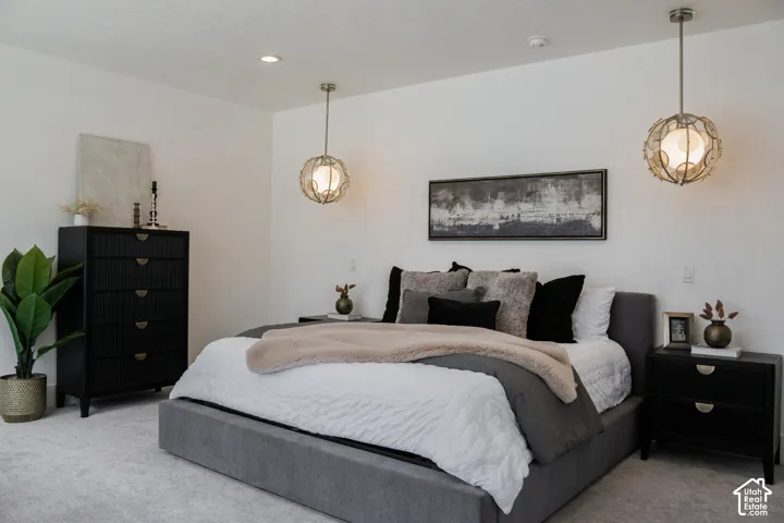Recessed ceiling lighting, textured wall-mounted pendant lights, light-toned carpeting, and a neutral wall palette