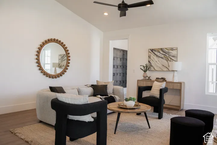 Vaulted ceiling with a ceiling fan, recessed lighting, wood-finish flooring, and white walls