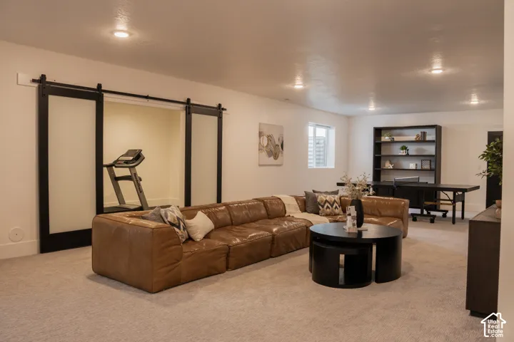 Recessed lighting, light-toned carpeting, and a built-in shelving unit with desk space