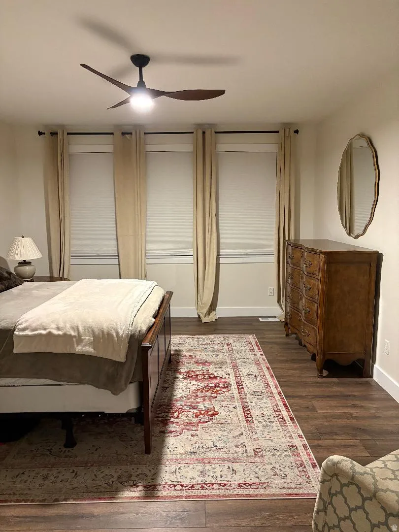 Wood-finish flooring throughout, complemented by a modern ceiling fan with integrated lighting
