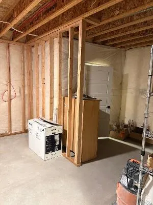 Unfinished space featuring wood framing, concrete flooring, and exposed ceiling joists