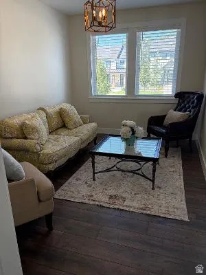 Wood-finish flooring, dual windows with blinds, and an overhead geometric light fixture