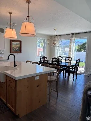 Kitchen island with a white solid surface countertop and farmhouse sink