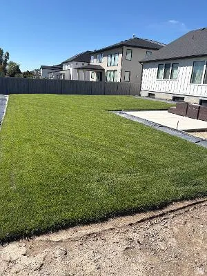 Expansive green lawn, concrete patio, and a dark privacy fence