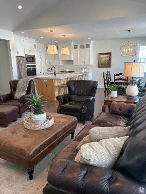 Open-concept living space featuring vaulted ceilings, recessed lighting, and wood-finish flooring