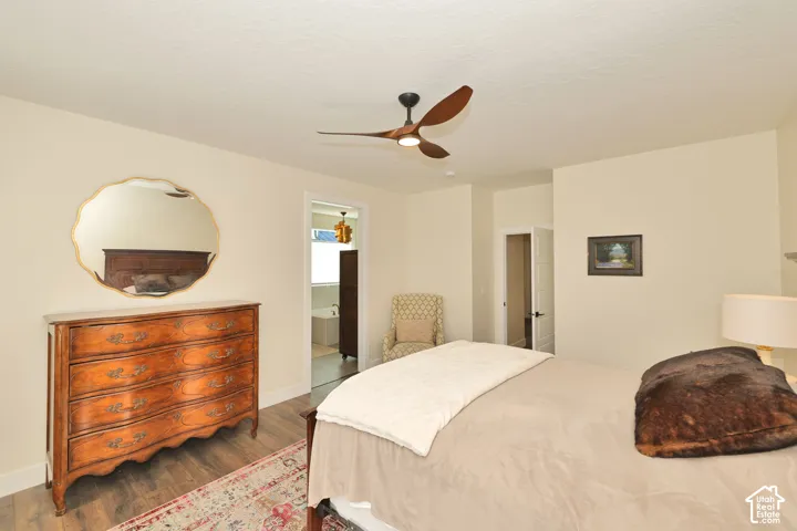 Wood-finish flooring, three-blade ceiling fan with integrated lighting, and multi-panel interior doors