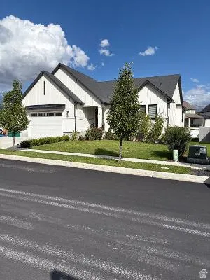 Modern farmhouse-style exterior with vertical white siding, black-framed windows, dark shingles, and an attached two-car garage