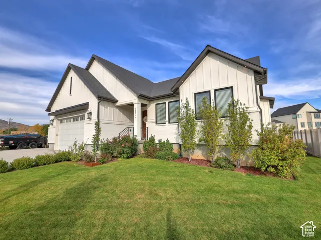 Modern farmhouse exterior featuring vertical board-and-batten siding, contrasting dark window frames, gabled rooflines, and a concrete driveway