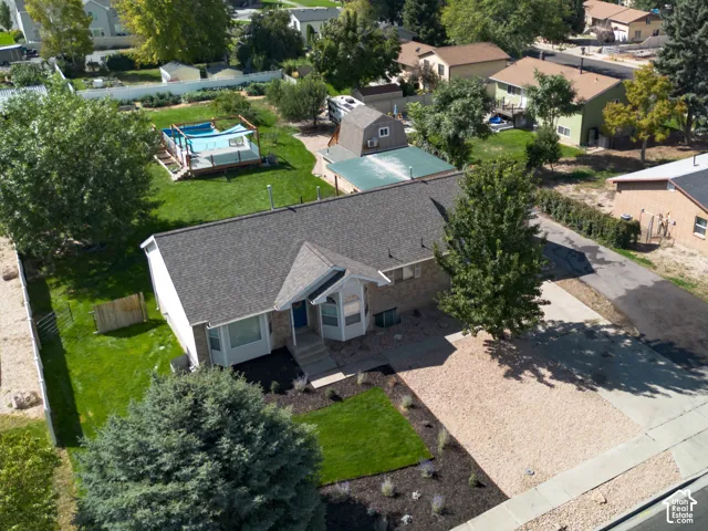 Single-story residence with a gray shingle roof, well-maintained front lawn, and mature trees