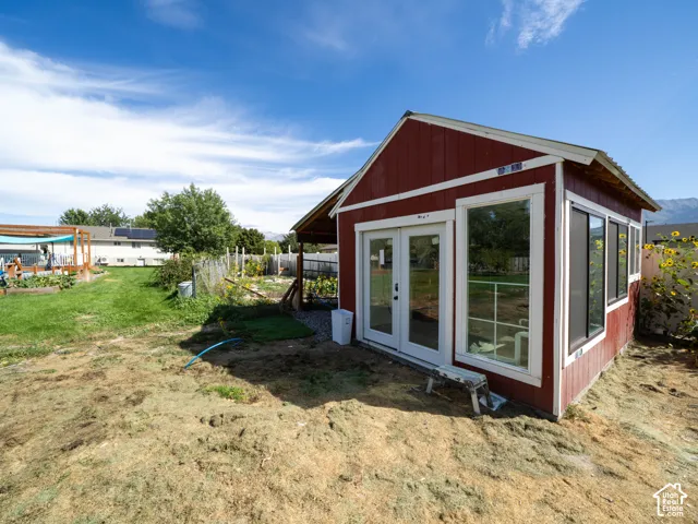 Red exterior structure with white trim and multiple windows, featuring double glass doors