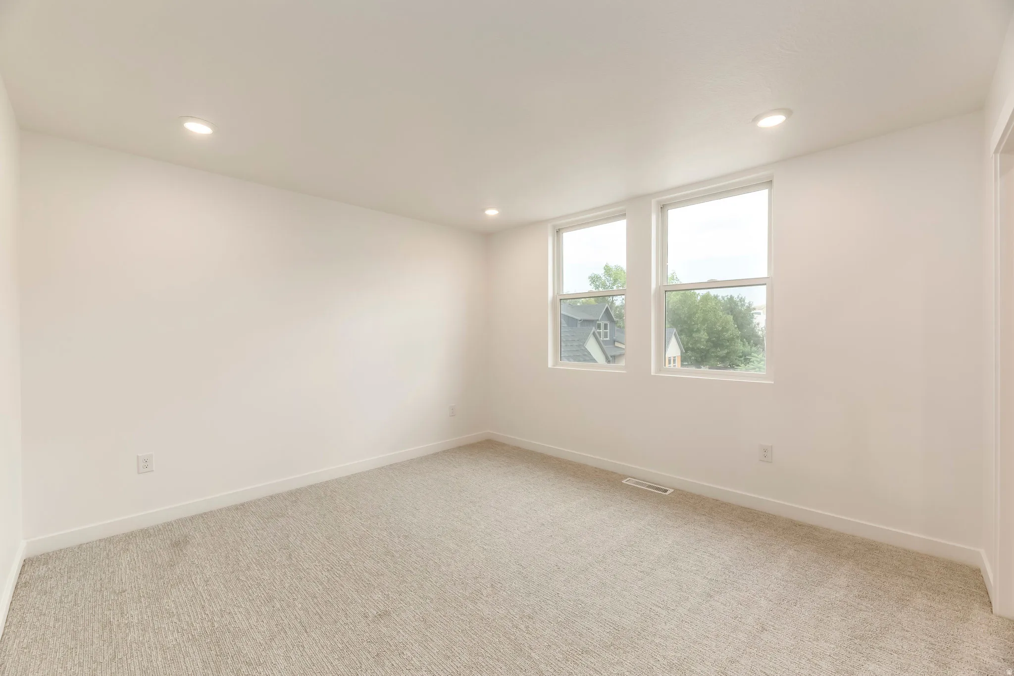 Recessed ceiling lighting, two windows, wall-to-wall carpeting, and white walls