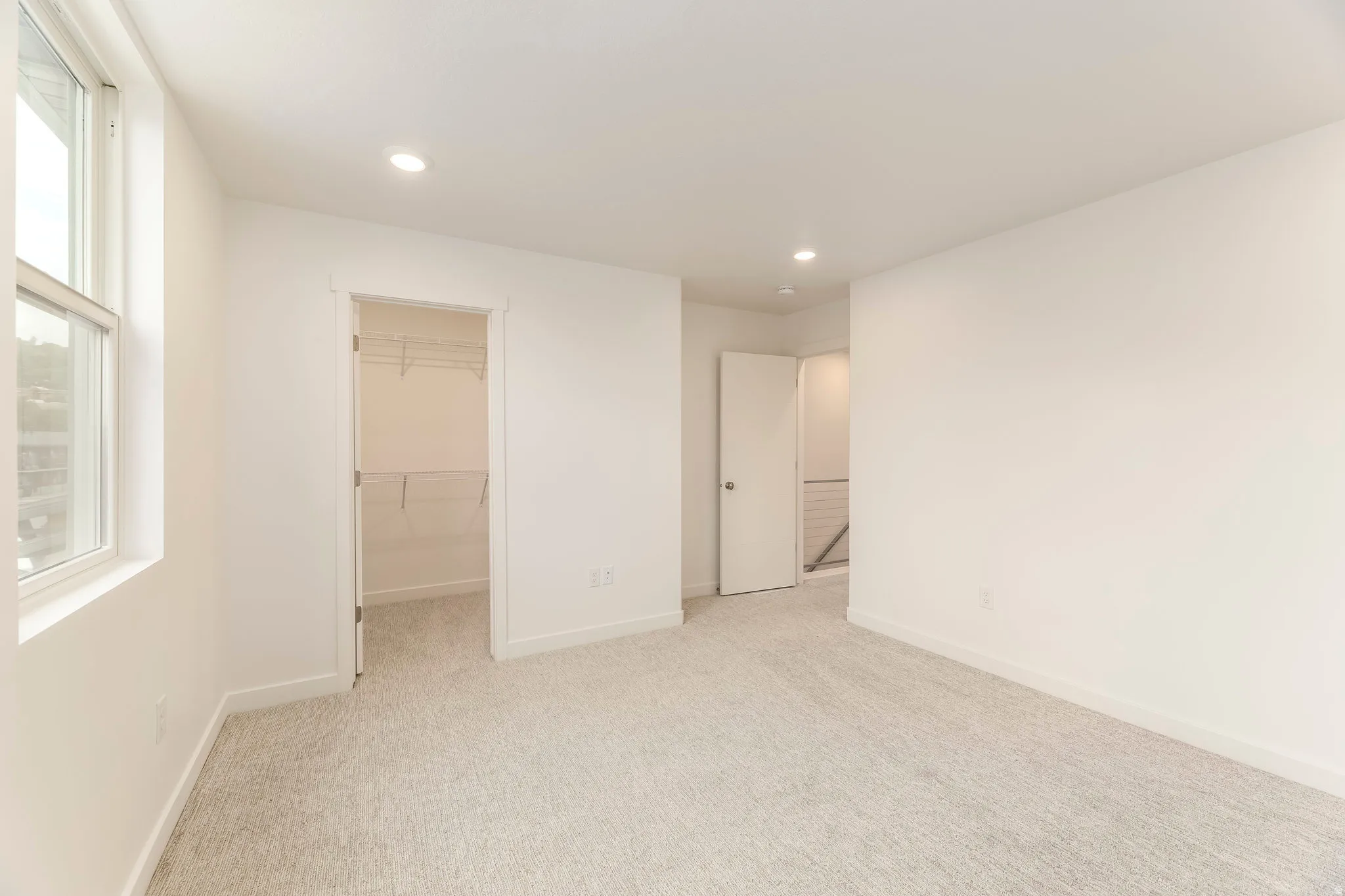Neutral wall finishes, carpeted flooring, recessed lighting, and a built-in closet system