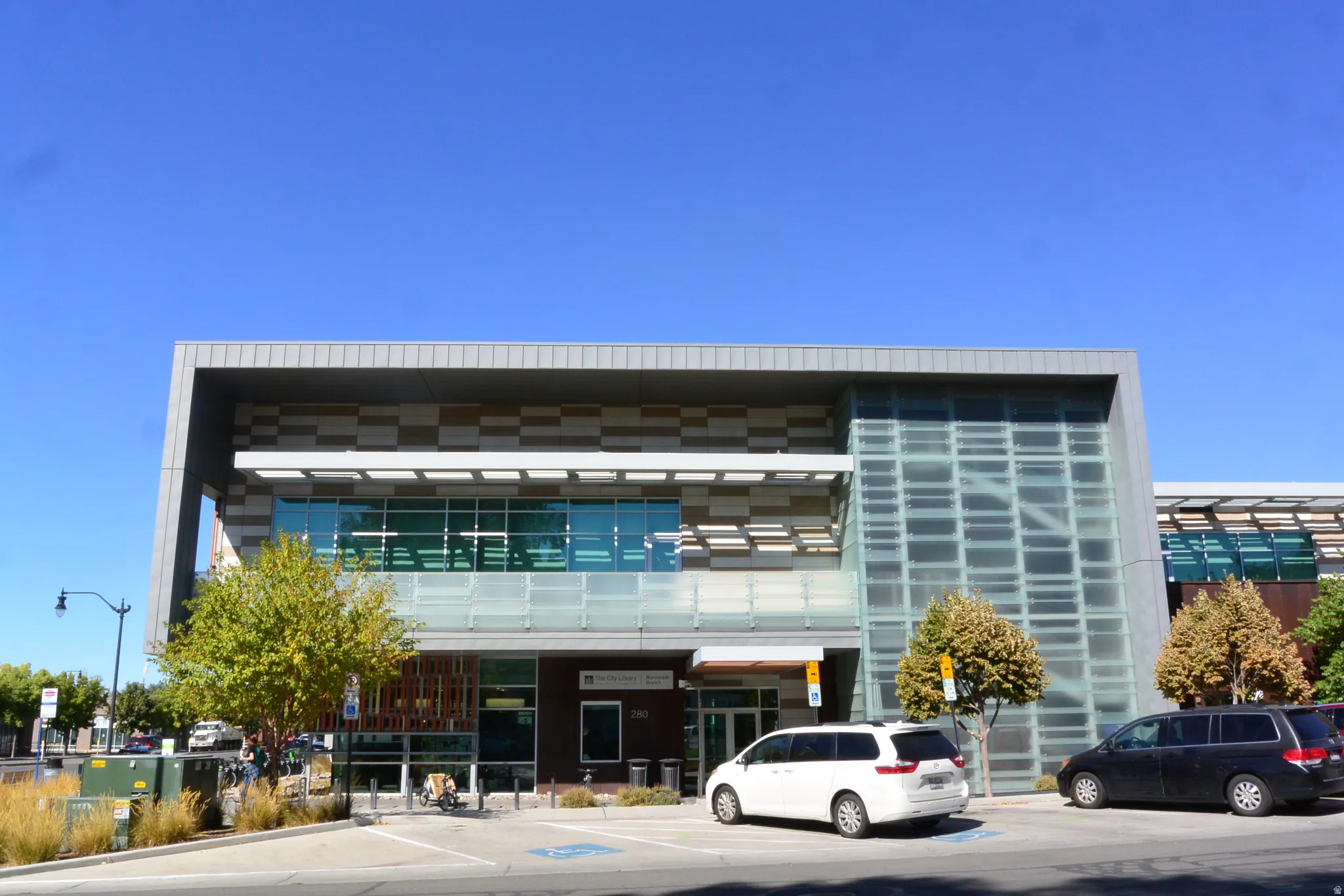Modern building exterior featuring a glass facade, metal paneling, and a prominent entrance