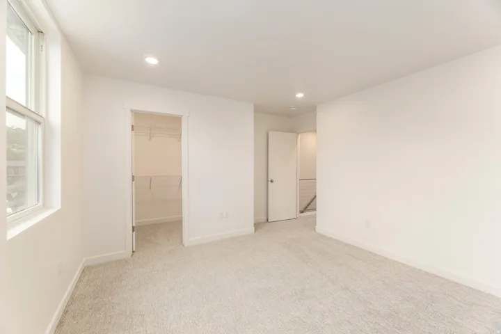 Neutral wall finishes, carpeted flooring, recessed lighting, and a built-in closet system