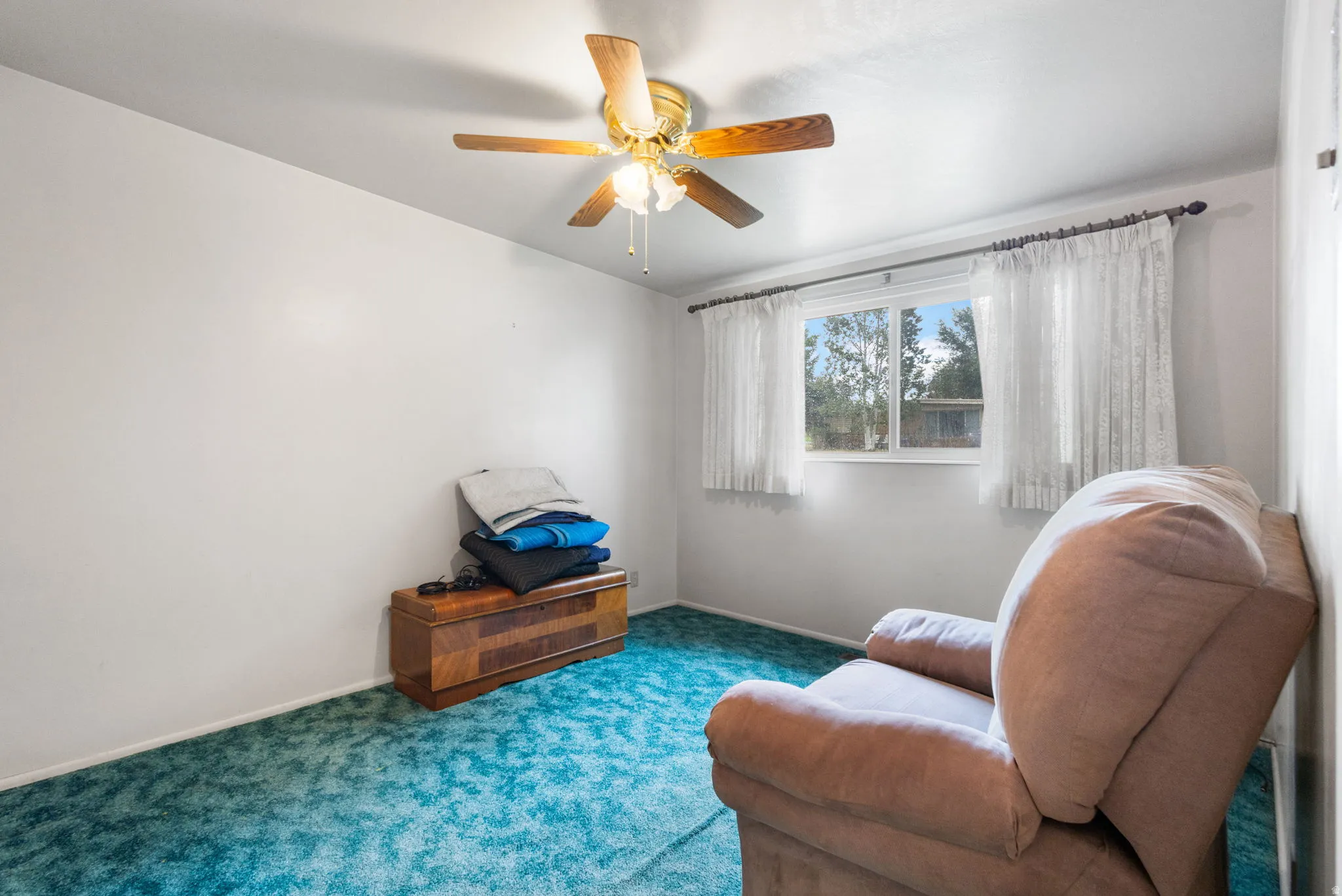 Room featuring a window, ceiling fan, and wall-to-wall carpeting