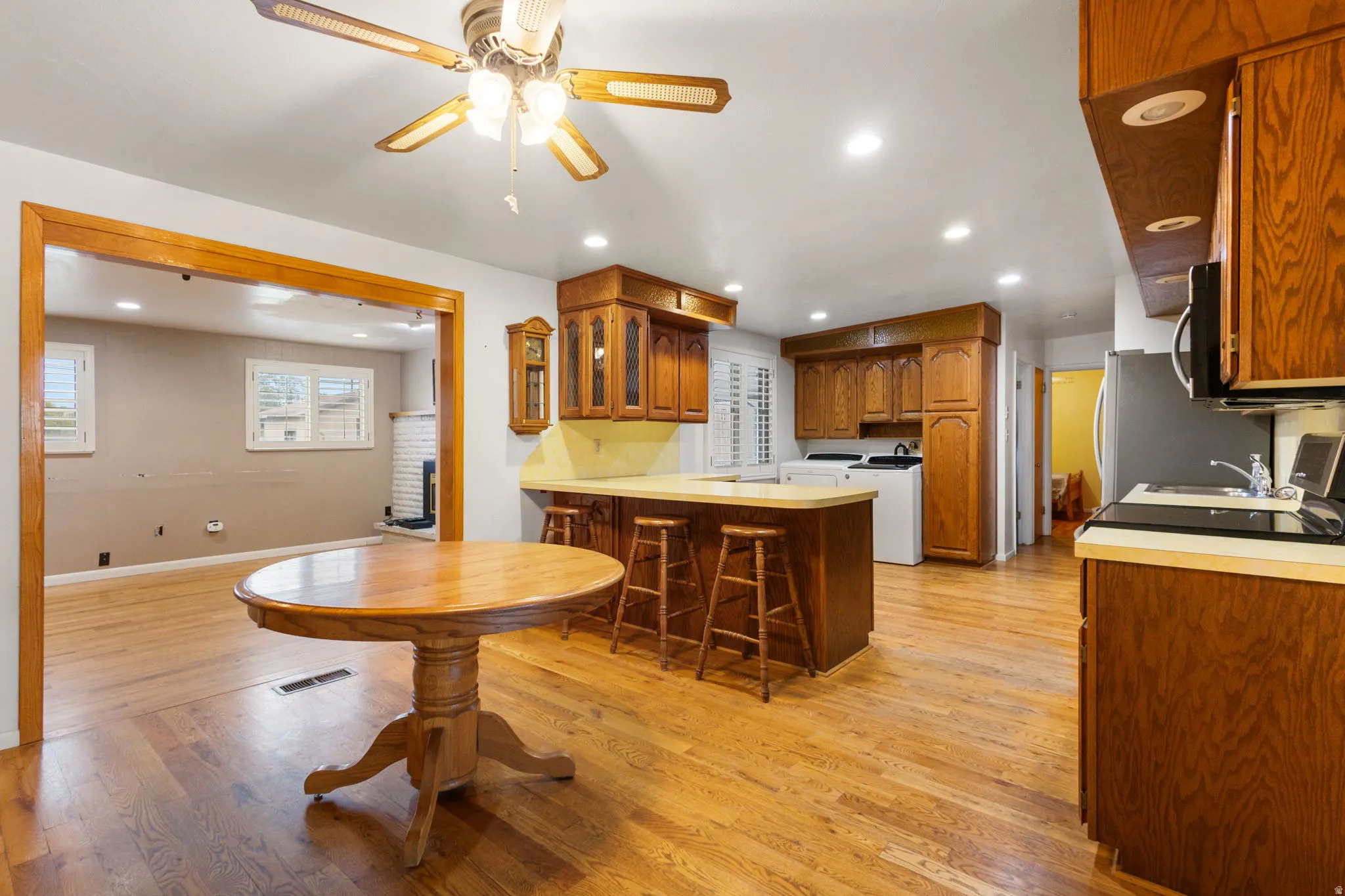 Kitchen featuring wood-finish cabinetry, light countertops, integrated appliances, and recessed lighting