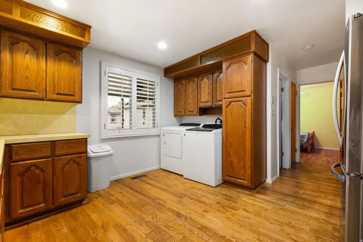 Wood-finish flooring throughout, solid wood cabinetry, ample counter space, recessed lighting, and a window with plantation shutters