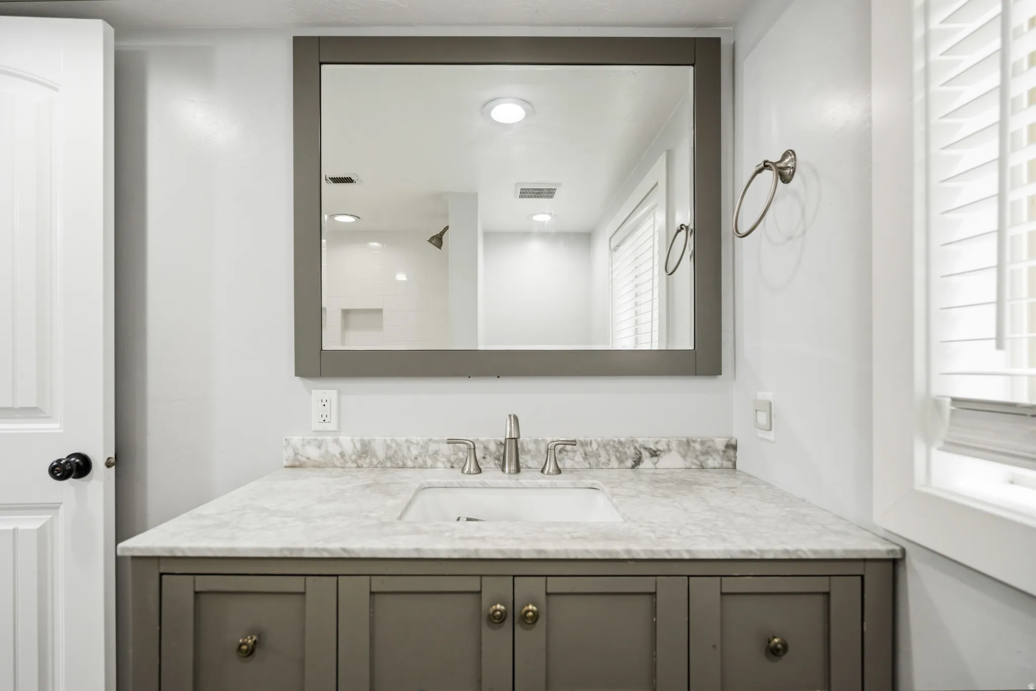 Vanity with a stone countertop, undermount sink, and brushed nickel faucet