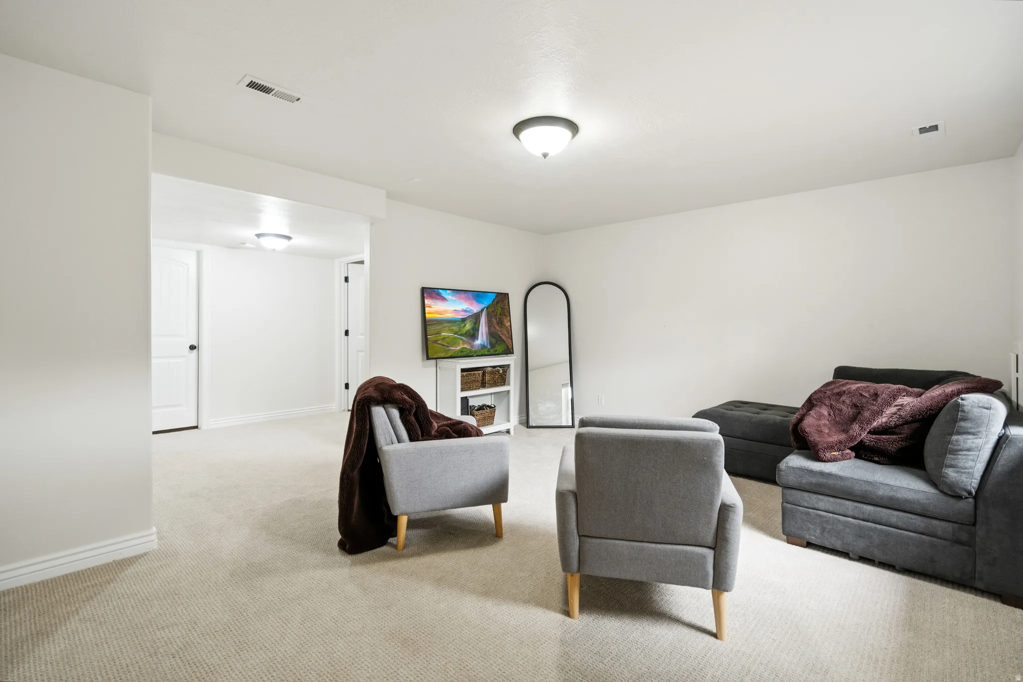Neutral carpet flooring and white painted walls create a bright interior
